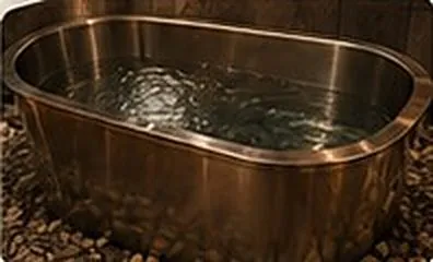 A steel cold-plunge tub filled with clear water.
